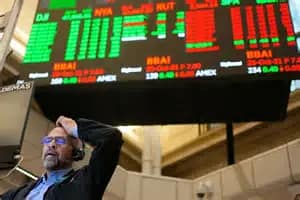 “Stock exchange trading floor with a large electronic board displaying market indices and a trader monitoring real‑time stock movements.