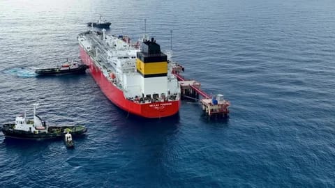 Commercial vessels crossing the Strait of Hormuz in a strategic and heavily monitored waterway.